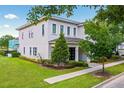 Modern two-story house with landscaped yard and walkway at 7423 Sparkling Ct, Reunion, FL 34747