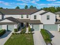 Two-story townhome with gray roof, light-colored siding, and attached garage at 1592 Wynford Cir, Tavares, FL 32778