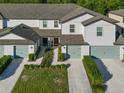 Two-story townhome community view, featuring multiple units with attached garages at 1592 Wynford Cir, Tavares, FL 32778