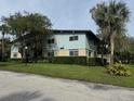 Exterior view of a light teal building with mature trees and landscaping at 1695 Lee Rd # B216, Winter Park, FL 32789