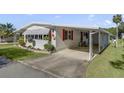 Front view of a white mobile home with covered parking at 210 Palm Meadows Dr, Eustis, FL 32726