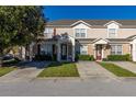 Two-story townhome with a light tan exterior and landscaping at 2361 Silver Palm Dr, Kissimmee, FL 34747