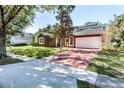 Two-story home with brick facade, solar panels, and a paver driveway at 723 Long Lake Dr, Oviedo, FL 32765