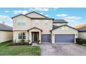 Two-story house with gray siding, purple garage doors, and a landscaped lawn at 2609 Mead Ave, St Cloud, FL 34771