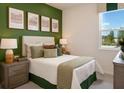 Cozy bedroom featuring green accents and a comfortable bed at 9097 Wildlight Trl, Wildwood, FL 34785