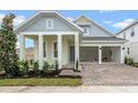 Two-story Craftsman home with gray siding, white columns, and a two-car garage at 15086 Summer Harvest St, Winter Garden, FL 34787