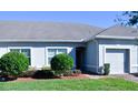 Front view of a single-Gathering home with a gray exterior, two-car garage, and manicured landscaping at 2825 Attwater Loop, Winter Haven, FL 33884