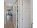 Long hallway with light gray walls and wood-look flooring at 7707 Country Pl, Winter Park, FL 32792