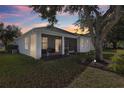 Screened porch with backyard access and lovely landscaping at dusk at 10227 Cypress Knee Cir, Orlando, FL 32825