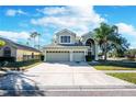 Two story house with three car garage and palm trees at 2338 Darlin Cir, Orlando, FL 32820