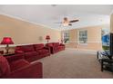 Spacious living room with red couches and carpeting at 1054 Waterside Dr, Celebration, FL 34747