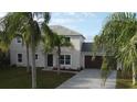 Two-story house with gray siding, brown garage door, and palm trees at 1115 Munster Ct, Kissimmee, FL 34759