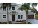 Two-story house with gray siding, brown garage door, and palm trees at 1115 Munster Ct, Kissimmee, FL 34759