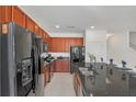 Modern kitchen with dark wood cabinets, black appliances, and granite countertops at 4481 Monado Dr, Kissimmee, FL 34746