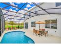 Screened pool area with patio furniture, a table, and umbrella at 4481 Monado Dr, Kissimmee, FL 34746
