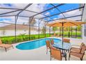 Screened pool and patio with lounge chairs and a table with seating for six at 4481 Monado Dr, Kissimmee, FL 34746