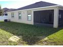 Home's backyard with screened patio, grass, and AC unit at 236 Barrington Dr, Haines City, FL 33844