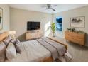 Light and airy bedroom with a dresser, nightstand, and a large TV at 4718 Rockvale Dr, Kissimmee, FL 34758