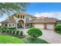 Two-story house with tile roof, three-car garage, and a brick paved driveway at 6245 Little Lake Sawyer Dr, Windermere, FL 34786