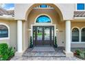 Elegant entryway with double doors, arched entry, and a stone pathway at 6245 Little Lake Sawyer Dr, Windermere, FL 34786