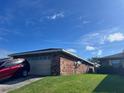 Brick home with attached garage and car parked in driveway at 661 Lake Carolyn Cir, Lakeland, FL 33813