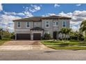 Two-story house with gray exterior, brown garage doors, and landscaping at 8192 Ludington Cir, Orlando, FL 32836