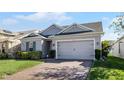 One-story house with gray siding, two-car garage, and landscaped lawn at 1731 Reflection Ln, Saint Cloud, FL 34771