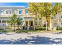 Front view of tan townhouses with landscaping and a walkway at 418 Water St, Kissimmee, FL 34747