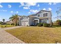 Two-story house with light gray siding, white garage door and a neatly manicured lawn at 755 Kildrummy Dr, Davenport, FL 33896