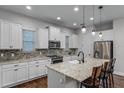 Spacious kitchen with white cabinets, granite countertops, and stainless steel appliances at 8279 Nemours Pkwy, Orlando, FL 32827
