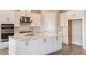 Modern kitchen with white cabinets, large island, and stainless steel appliances at 925 Tassleflower Trl, St Cloud, FL 34771