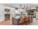 Spacious gourmet kitchen with stainless steel appliances, an island with seating, and wood floors at 932 Tassleflower Trl, Saint Cloud, FL 34771
