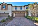 Townhouse exterior featuring a brick facade and two-car garage at 1204 Payne Stewart Dr, Davenport, FL 33896