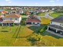 Backyard view of a home with a large lawn and lake access at 1651 Kingfisher Ct, Kissimmee, FL 34746