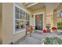 Front entrance with a wooden bench, autumn wreath, and potted plants at 1812 Arbor Lakes Cir # 1812, Sanford, FL 32771