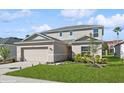 Two-story house with beige siding, a two-car garage, and landscaping at 5286 Tuscany Ln, Davenport, FL 33897