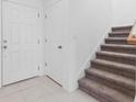 Front entry with white door, storage closet and carpeted staircase at 5286 Tuscany Ln, Davenport, FL 33897