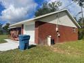 Brick house side view, showing the garage and utility area at 2355 Cypress Rd, Deland, FL 32724