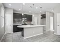 Modern kitchen with dark cabinetry, island, and stainless steel appliances at 3207 Stratton Cir, Kissimmee, FL 34744