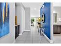 Bright entryway with tile floors, blue accent wall, and a view into the living room at 7457 Marker Ave, Kissimmee, FL 34747