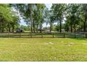 Landscaped yard with trees and a wooden fence at 12128 Sw 41St Pl, Ocala, FL 34481