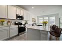 Bright kitchen with white cabinets, quartz countertops and an island at 2306 Amorie Dr, Kissimmee, FL 34746