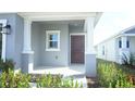Charming front porch entryway with a dark brown door and white columns at 2343 Amorie Dr, Kissimmee, FL 34746