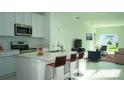 Open concept kitchen features island with seating, stainless steel appliances, and white cabinets at 2343 Amorie Dr, Kissimmee, FL 34746