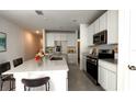 Modern kitchen with stainless steel appliances and white cabinetry, features an island at 2343 Amorie Dr, Kissimmee, FL 34746