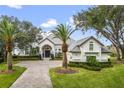 Stunning white two-story home with palm trees and manicured lawn at 6009 Lady Bet Dr, Orlando, FL 32819