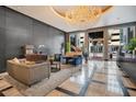 Elegant lobby with seating area, grand chandelier, and piano at 100 S Eola Dr # 1411, Orlando, FL 32801