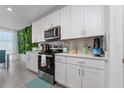 White kitchen with stainless steel appliances and a green wall at 1251 Citrus Landing Blvd, Davenport, FL 33837