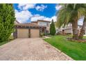 Two-story home with stone accents and a two-car garage, beautifully landscaped at 15939 Vetta Dr, Bella Collina, FL 34756