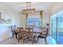 Bright dining room featuring a rustic wooden table and soft green curtains at 3974 Mekong Ct, Saint Cloud, FL 34772